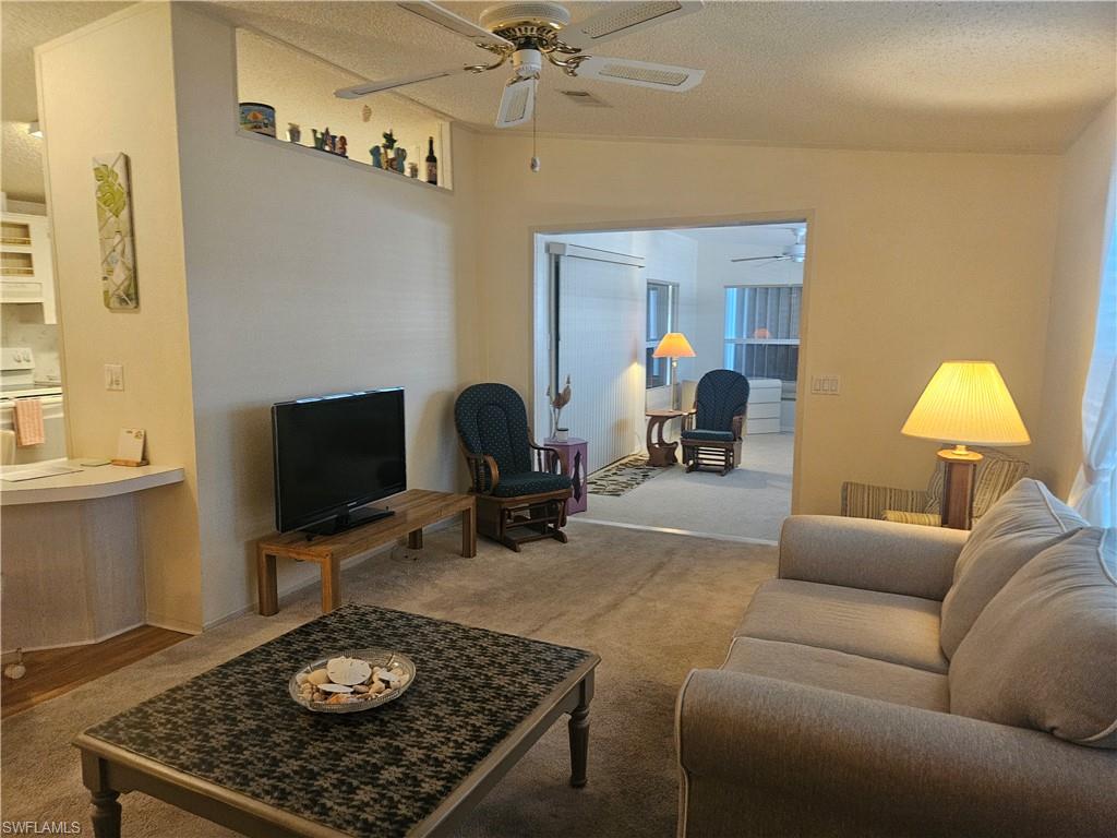 38 Turquoise Avenue, Unit 38T Naples, FL 34114 - Photo 11 of 29 a living room with furniture and a flat screen tv