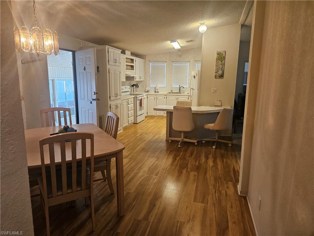 38 Turquoise Avenue, Unit 38T Naples, FL 34114 - Photo 14 of 29 a view of a dining room with furniture and wooden floor