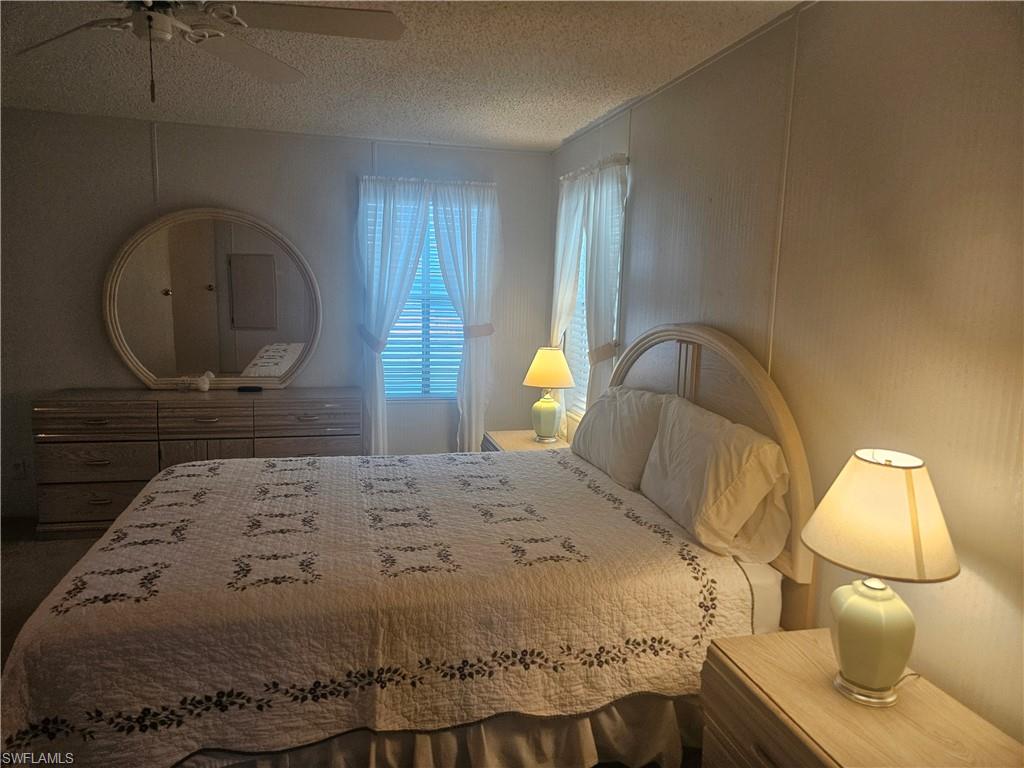 38 Turquoise Avenue, Unit 38T Naples, FL 34114 - Photo 15 of 29 a bedroom with a bed and a mirror