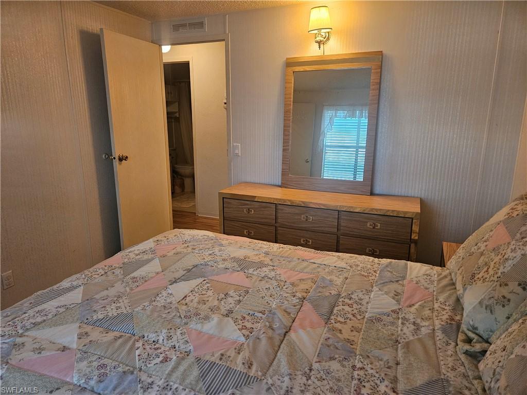 38 Turquoise Avenue, Unit 38T Naples, FL 34114 - Photo 21 of 29 a bedroom with a bed and a mirror