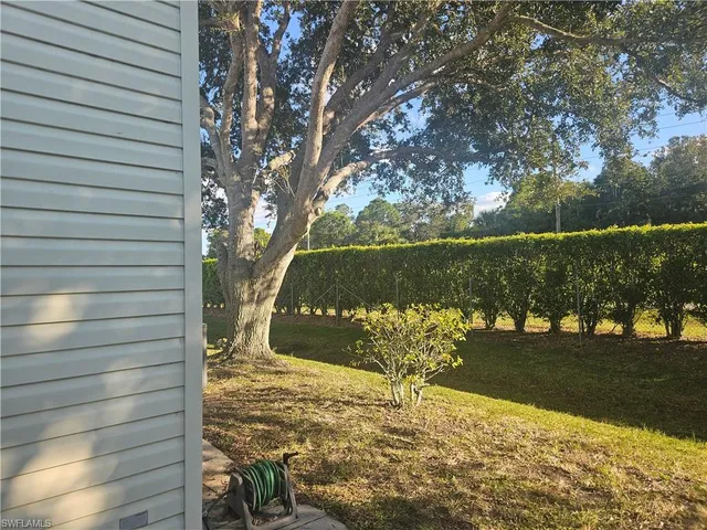 a view of a yard with wooden fence