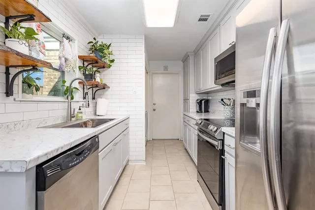 a kitchen with stainless steel appliances granite countertop a sink and a stove