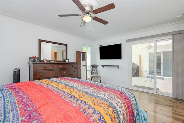 a spacious bedroom with a bed and a flat screen tv