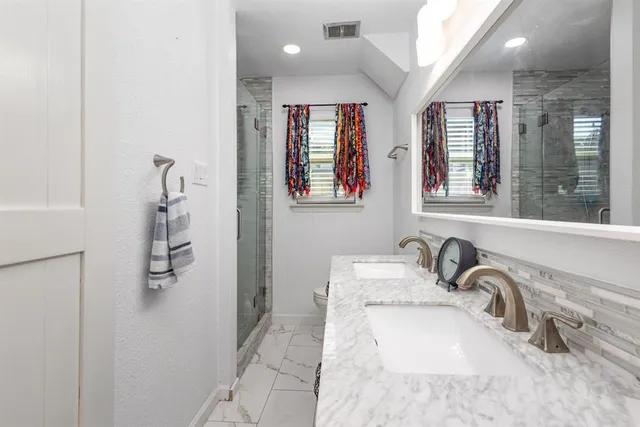 a bathroom with a granite countertop sink a large mirror and a bathtub