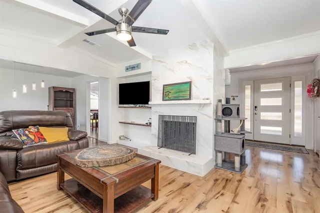 a living room with furniture a fireplace and a flat screen tv