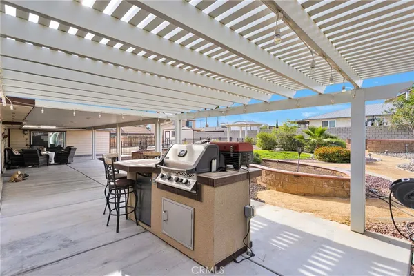 a view of a patio with table and chairs next to a yard