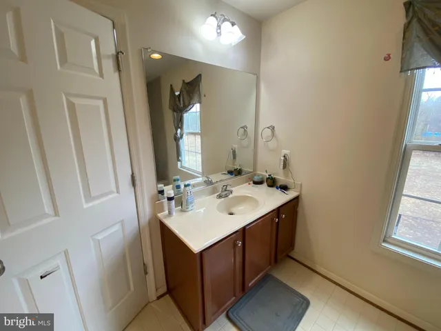 a bathroom with a sink vanity and a mirror