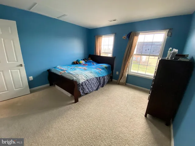 a spacious bedroom with a bed and a window