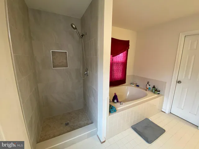 a bathroom with a sink vanity tub and shower