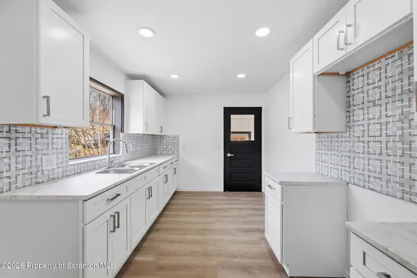 a view of a hallway with wooden floor and windows