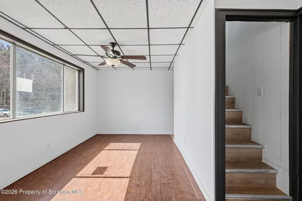 a view of a room with a large window and wooden floor