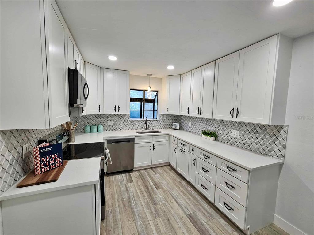 5407 Southwest 82 Terrace Gainesville, FL 32608 - Photo 7 of 31 a kitchen with granite countertop white cabinets and white appliances