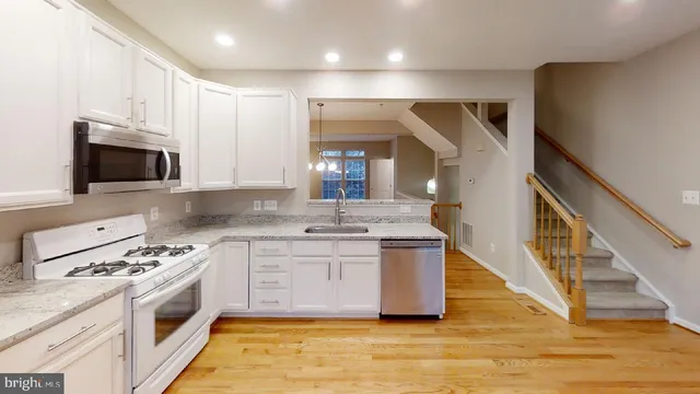 a large kitchen with stainless steel appliances granite countertop a stove and a sink