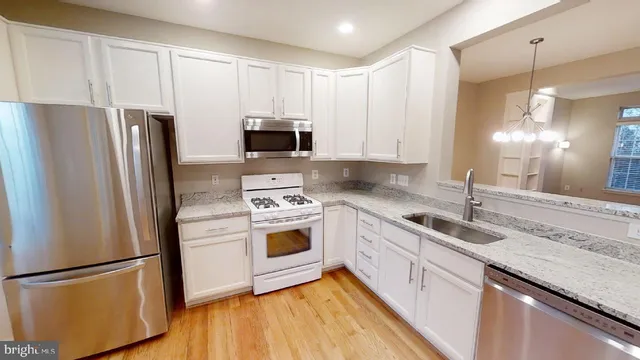 a kitchen with stainless steel appliances a refrigerator sink and microwave
