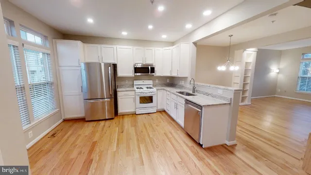 a kitchen with stainless steel appliances granite countertop a refrigerator a stove a sink and a microwave