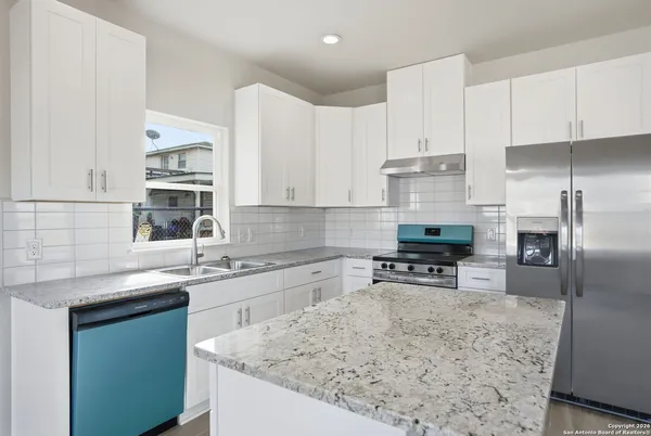 a kitchen with a sink a counter top space stainless steel appliances and cabinets