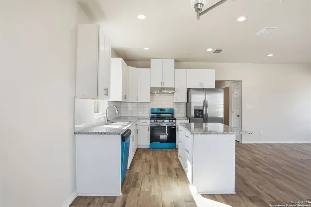 a kitchen with granite countertop a sink stove and refrigerator