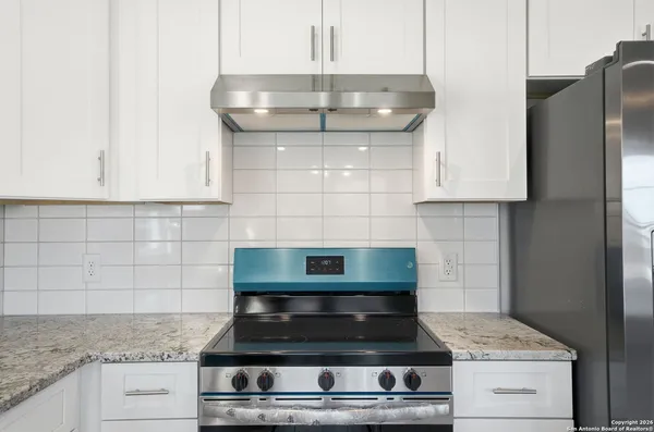 a kitchen with a stove a sink and a refrigerator