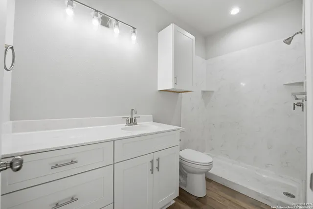 a bathroom with a sink a toilet and shower