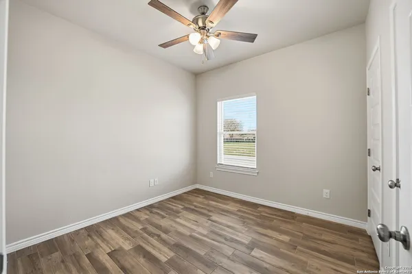 a view of an empty room with wooden floor