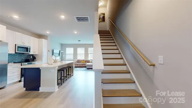 a view of a kitchen with sink and wooden floor