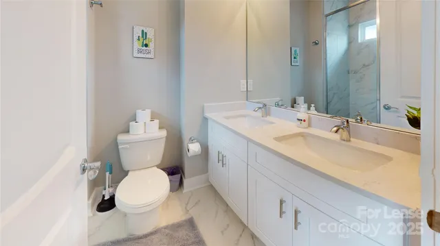 a bathroom with a granite countertop sink a toilet and a mirror