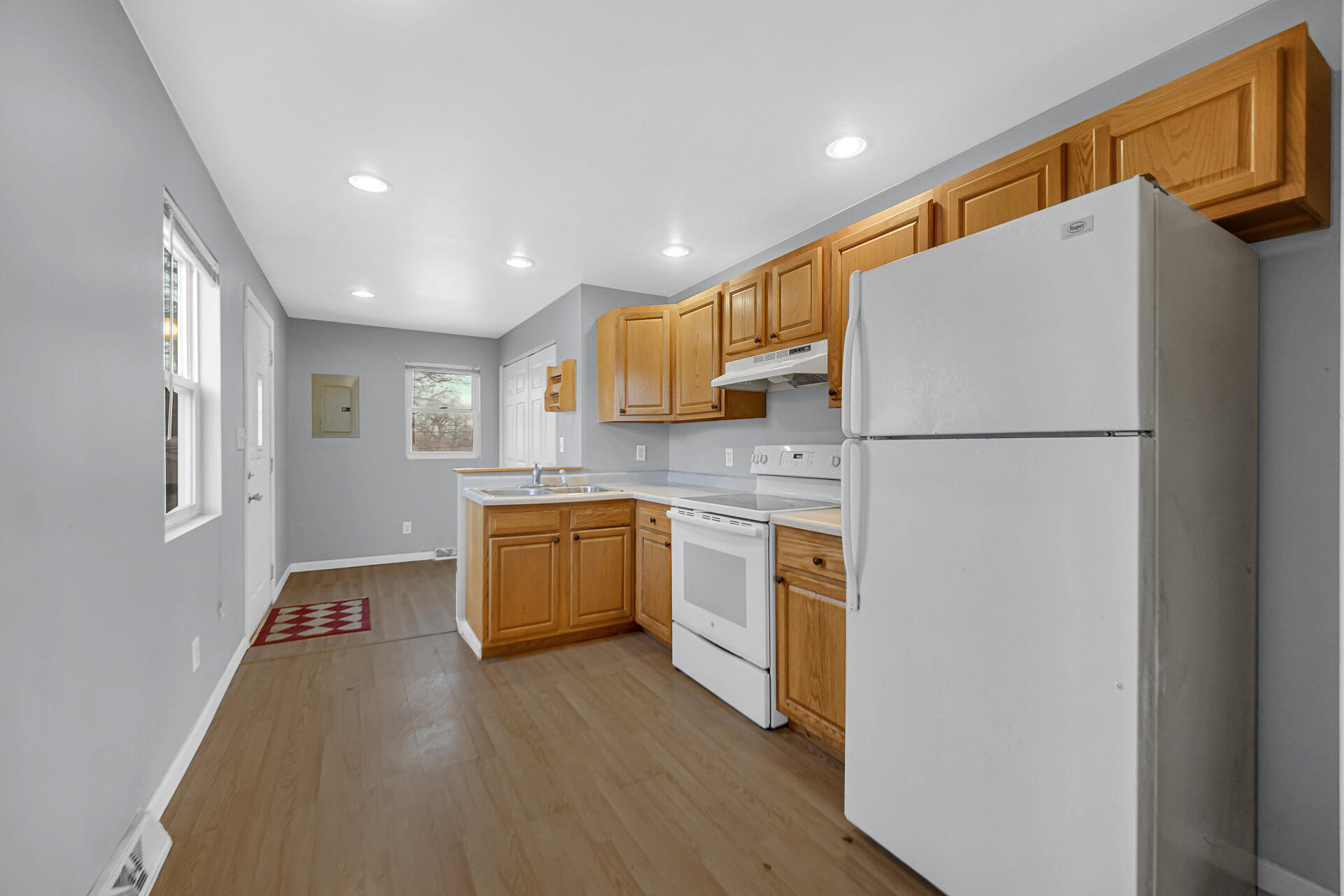 2228 Riverside Drive Lake Station, IN 46405 - Photo 3 of 22 a kitchen with a refrigerator a stove top oven a sink and dishwasher with wooden floor