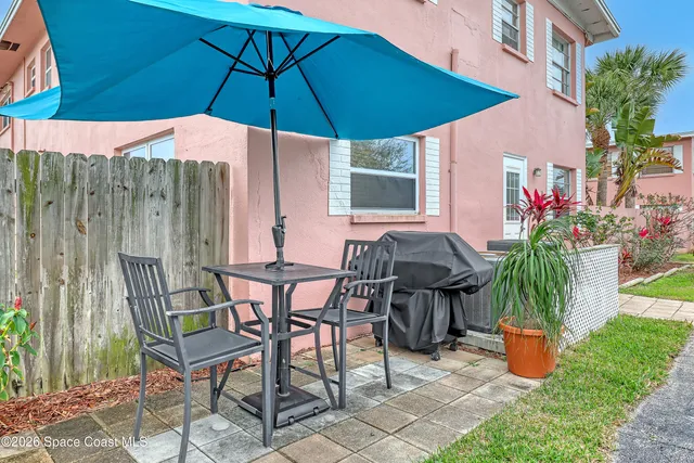 a patio with a table and chairs under an umbrella
