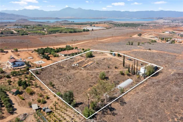 an aerial view of residential houses with outdoor space and ocean view