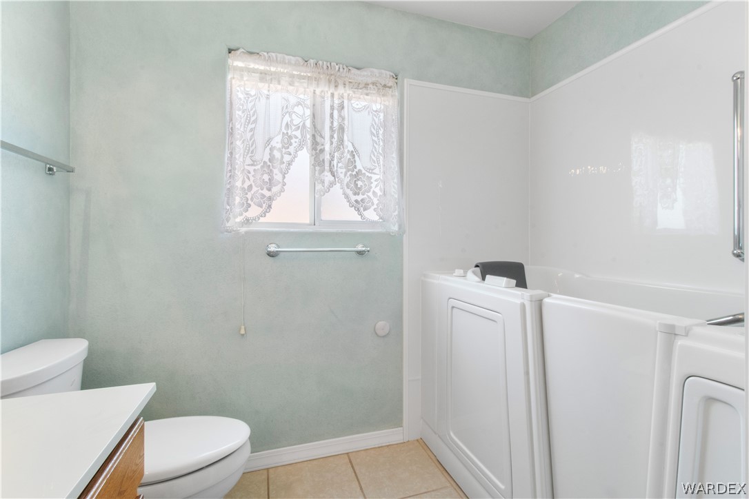 2158 Ranch Road Kingman, AZ 86401 - Photo 21 of 48 a white toilet sitting next to a bathroom sink and vanity