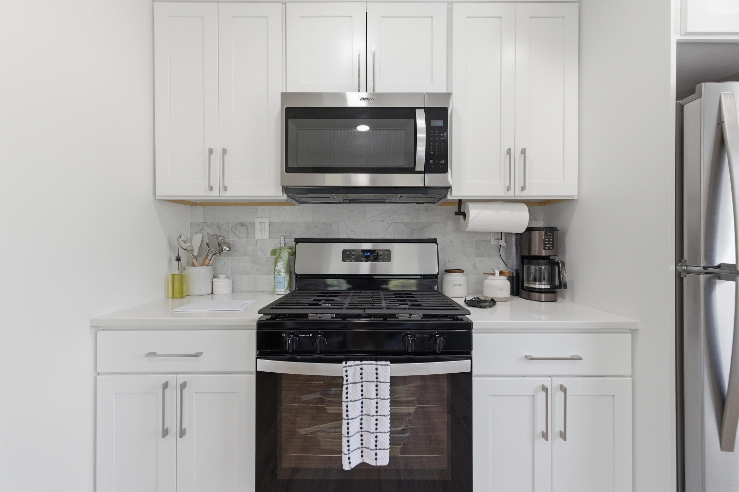 209 Breakwater Road North Cape May, NJ 08204 - Photo 11 of 40 a kitchen with stainless steel appliances granite countertop white cabinets a stove a sink and dishwasher