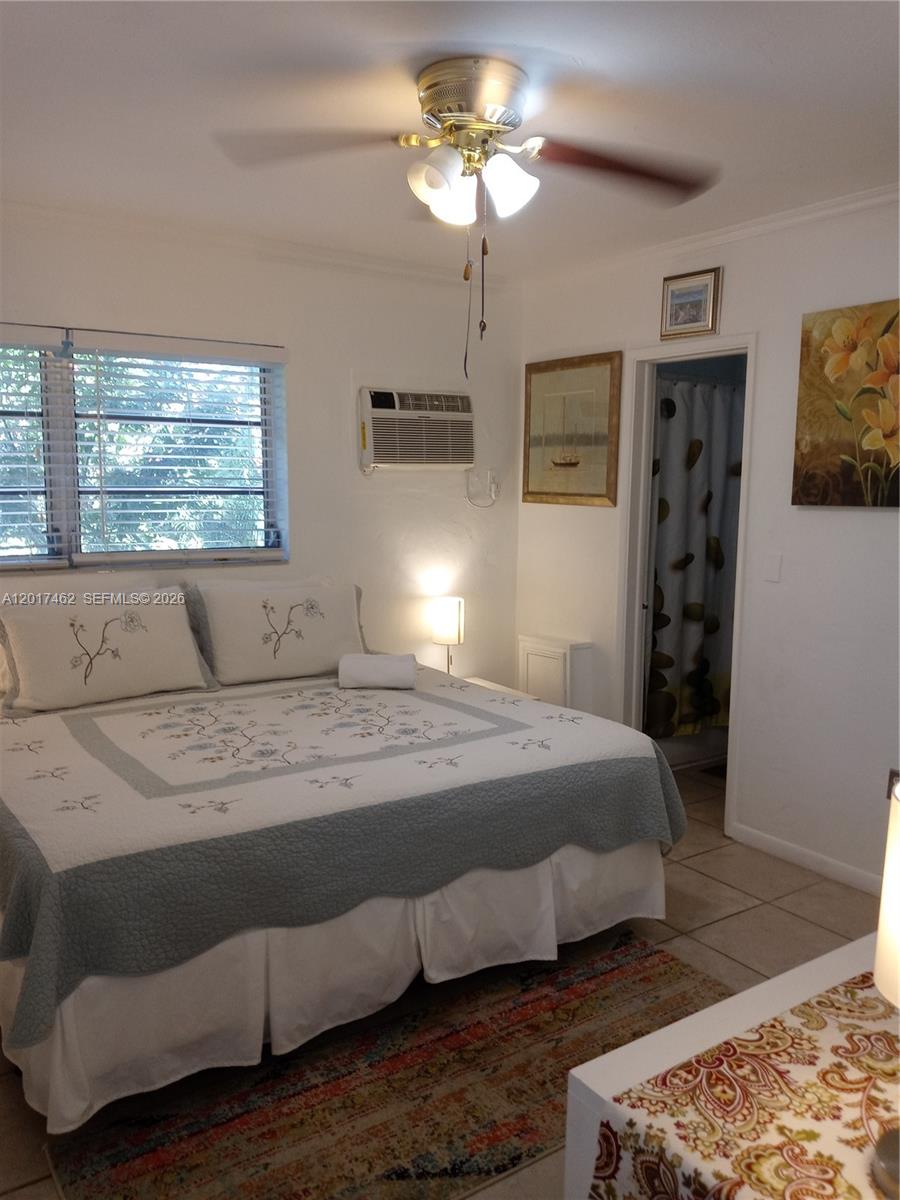 325 Fernwood Road, Unit 10 Key Biscayne, FL 33149 - Photo 10 of 12 a bedroom with a bed and a chandelier