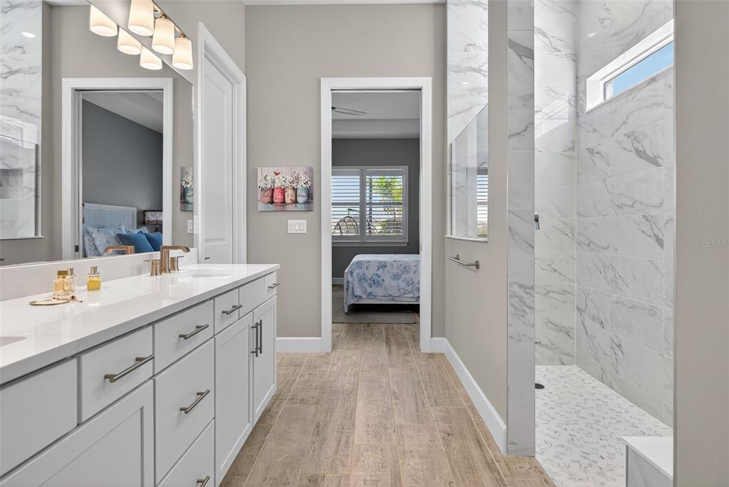 26532 Key Sands Street Englewood, FL 34223 - Photo 42 of 97 a en suite spacious bathroom with a double vanity sink a mirror and a shower