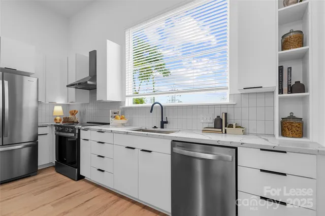 a kitchen with kitchen island granite countertop a large stove a sink and dishwasher with wooden floor