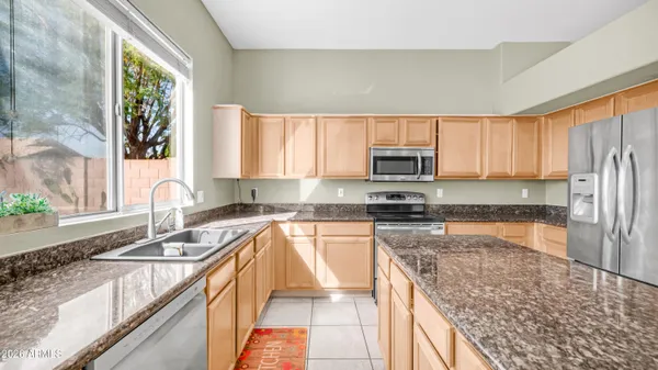 a kitchen with granite countertop a sink stove and refrigerator
