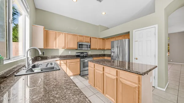 a kitchen with granite countertop a refrigerator stove and microwave