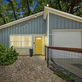 a view of house with backyard and plants