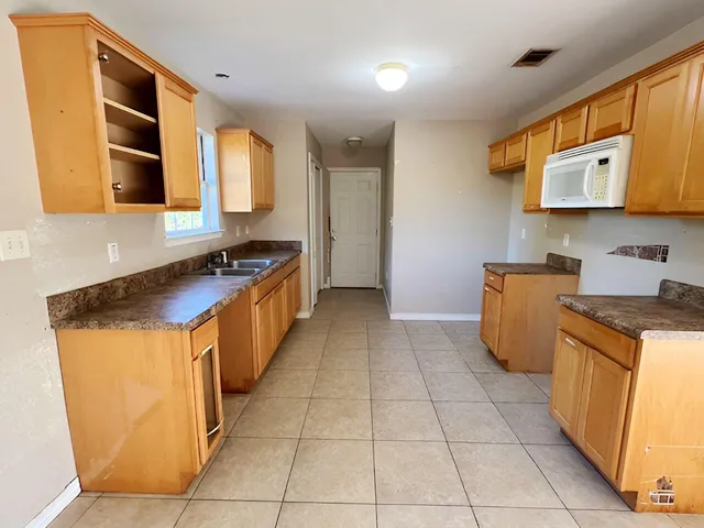 a kitchen with stainless steel appliances granite countertop a stove a sink and a microwave