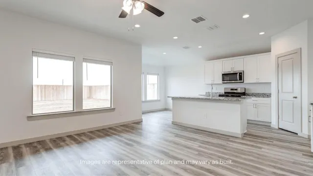 a kitchen with granite countertop white cabinets and black stainless steel appliances