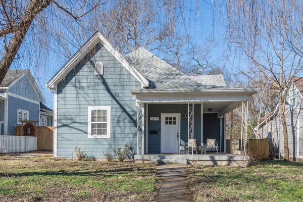 a view of a house with large windows and a yard