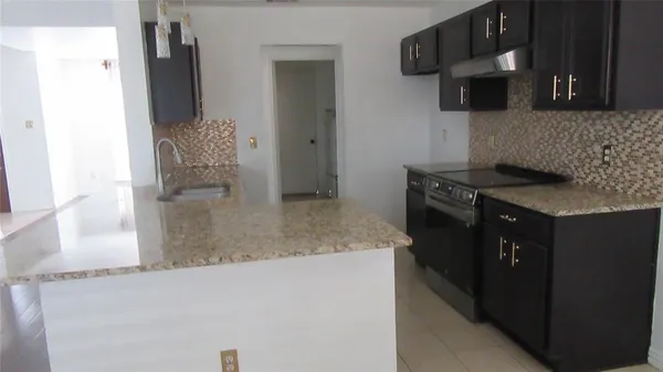 a kitchen with stainless steel appliances granite countertop a sink and a stove