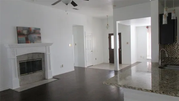 a view of a livingroom with wooden floor and a fireplace