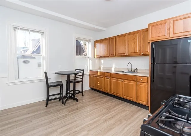 a kitchen with a refrigerator a stove a sink and cabinets
