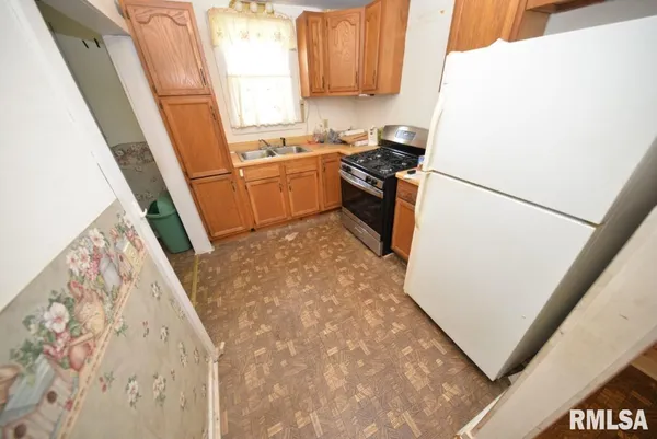 a kitchen with a refrigerator a stove a sink and a window