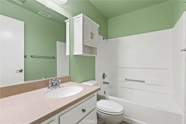 an empty room with windows and ceiling fan