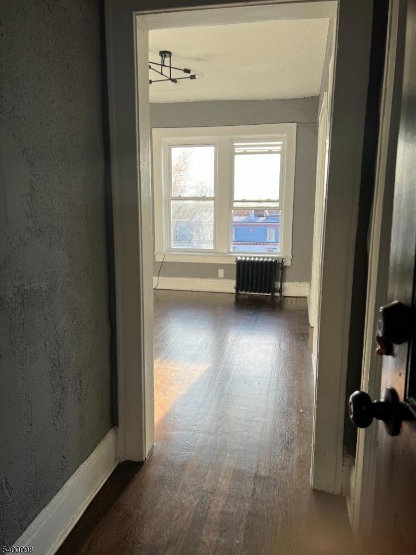 715 Arlington Avenue, Unit 2D Plainfield, NJ 07060 - Photo 3 of 4 an empty room with wooden floor and a window
