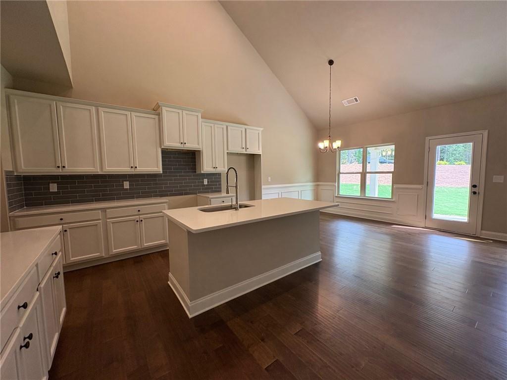 946 Lakeview Oaks Court Grayson, GA 30017 - Photo 16 of 25 a kitchen with granite countertop a stove a sink a refrigerator and white cabinets with wooden floor