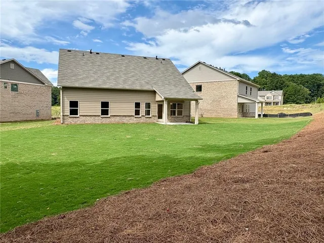 a view of a house with a yard and large tree