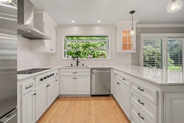 a kitchen with cabinets appliances and a large window