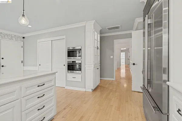 a hallway view with wooden floor and cabinets